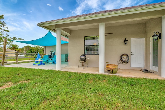 back of house with ceiling fan, a patio area, and a lawn