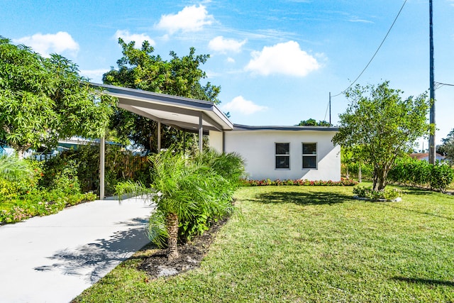 view of front of house with a carport and a front yard