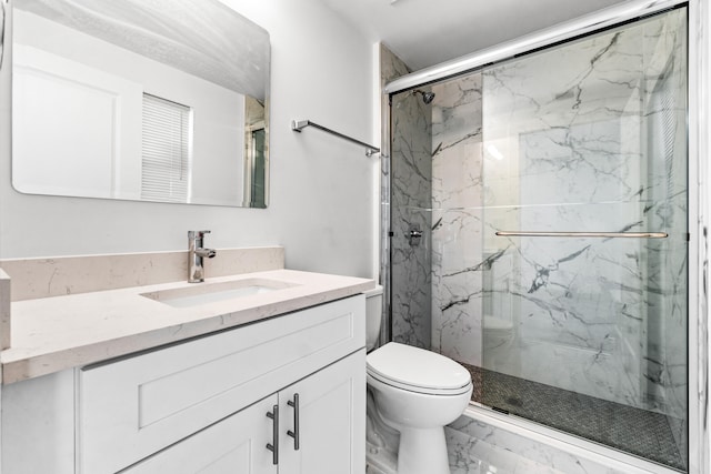 bathroom with vanity, toilet, and a shower with shower door