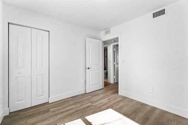 unfurnished bedroom with hardwood / wood-style flooring and a closet