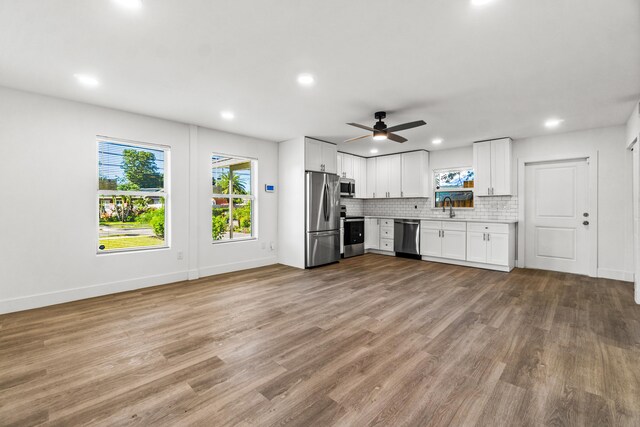 kitchen with white cabinetry, sink, ceiling fan, stainless steel appliances, and light wood-type flooring