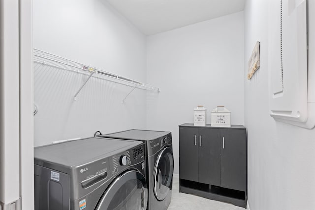 laundry area featuring light tile patterned flooring and washing machine and clothes dryer