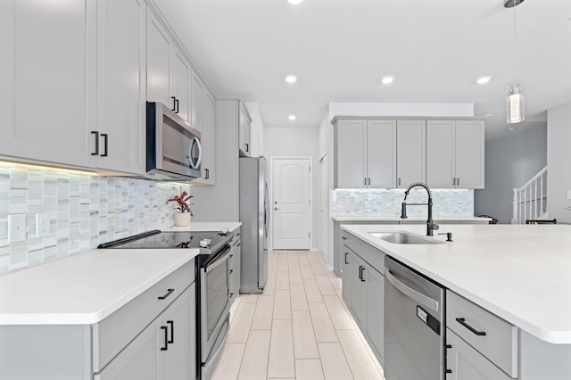 kitchen featuring backsplash, decorative light fixtures, sink, and stainless steel appliances