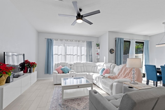 living room with ceiling fan and light hardwood / wood-style flooring