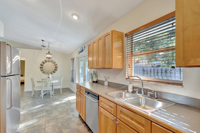 kitchen featuring decorative light fixtures, sink, stainless steel appliances, and a wealth of natural light