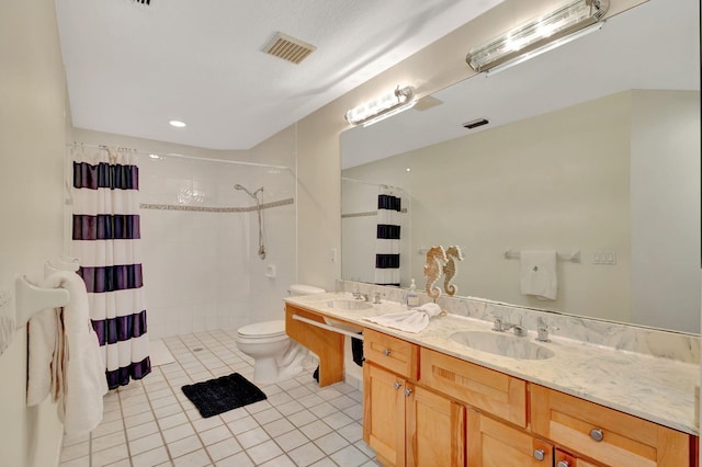 bathroom with tile patterned floors, curtained shower, vanity, and toilet