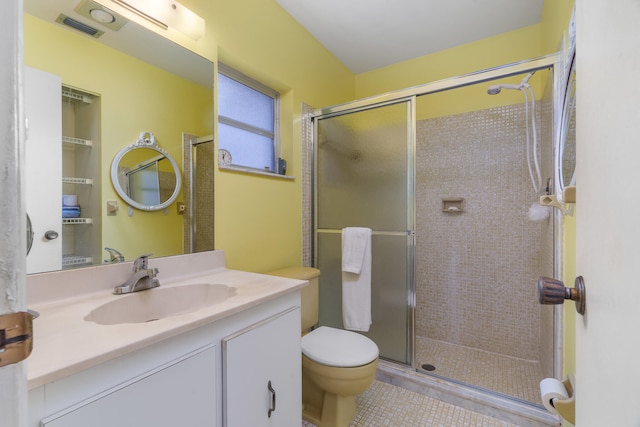 bathroom with toilet, vanity, tile patterned floors, and walk in shower