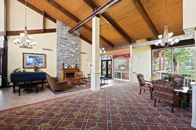 interior space with vaulted ceiling with beams, a stone fireplace, wood ceiling, and ornate columns