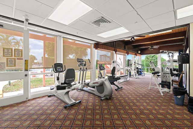 exercise room featuring carpet, a paneled ceiling, and ceiling fan