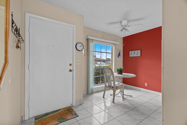 foyer with ceiling fan, light tile patterned flooring, and a textured ceiling