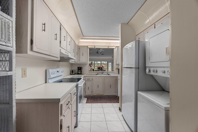 kitchen featuring sink, light tile patterned flooring, a textured ceiling, white appliances, and white cabinets