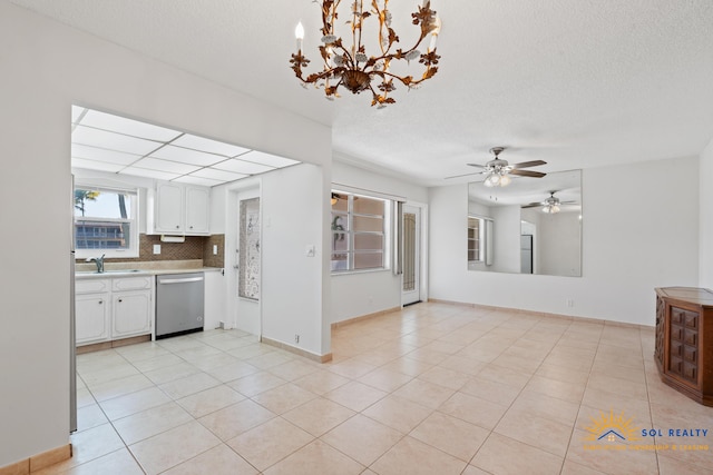 unfurnished living room with ceiling fan with notable chandelier, light tile patterned flooring, sink, and a textured ceiling