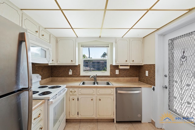 kitchen with backsplash, sink, light tile patterned floors, and stainless steel appliances