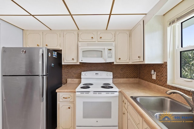 kitchen featuring decorative backsplash, white appliances, a drop ceiling, and sink