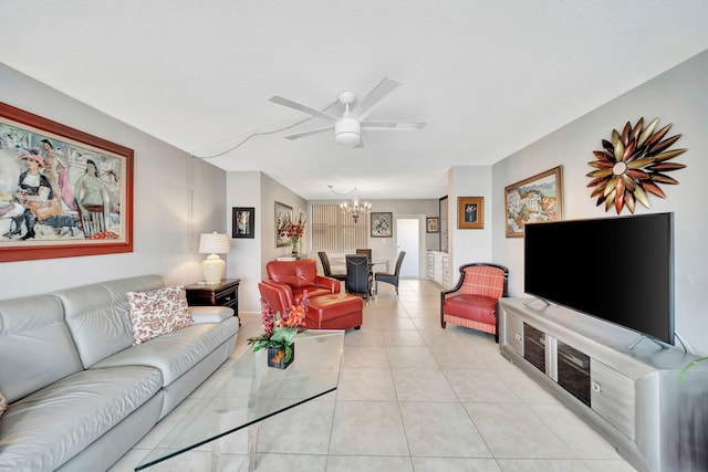 tiled living room with ceiling fan with notable chandelier