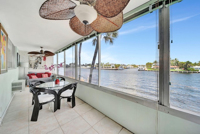 sunroom featuring a water view, a wall unit AC, and ceiling fan