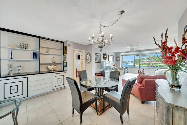 tiled dining area with ceiling fan with notable chandelier and a textured ceiling