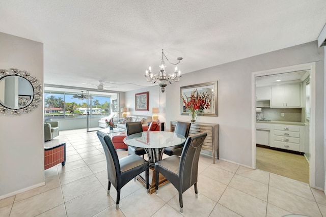 dining room featuring ceiling fan with notable chandelier, light tile patterned floors, a textured ceiling, and sink