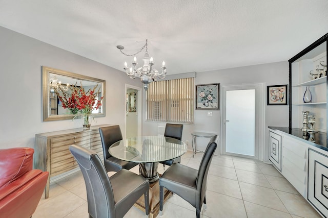 tiled dining room with a textured ceiling and a notable chandelier