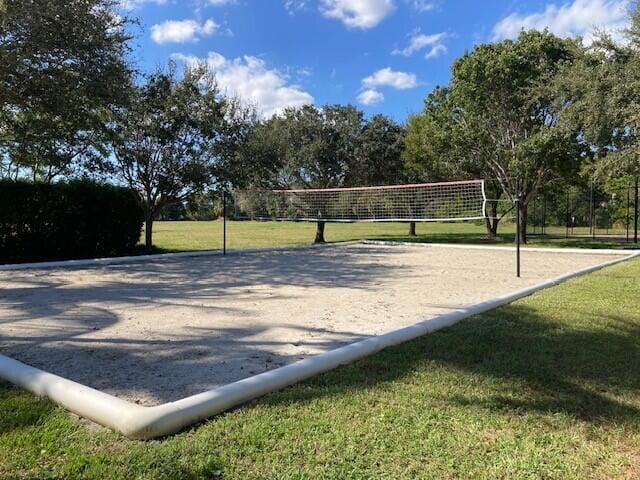 surrounding community with a lawn and volleyball court