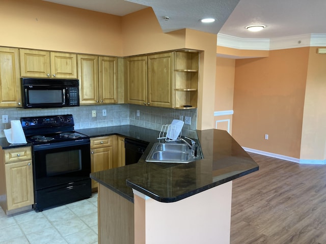 kitchen with black appliances, sink, light wood-type flooring, ornamental molding, and kitchen peninsula