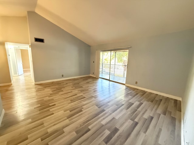 unfurnished room with high vaulted ceiling and light wood-type flooring