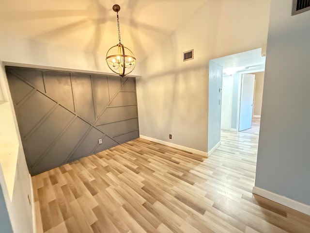 interior space featuring high vaulted ceiling, a chandelier, and light wood-type flooring