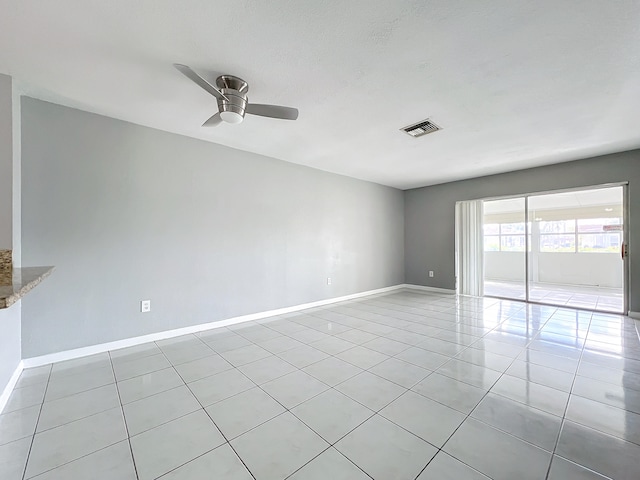 unfurnished room with ceiling fan and light tile patterned floors