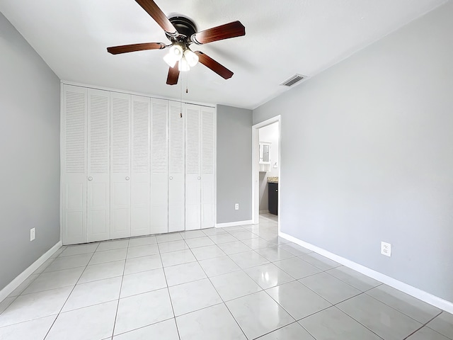 unfurnished bedroom featuring a closet, ceiling fan, and light tile patterned flooring