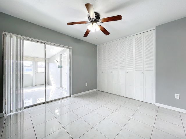 unfurnished bedroom with ceiling fan, a closet, and light tile patterned flooring