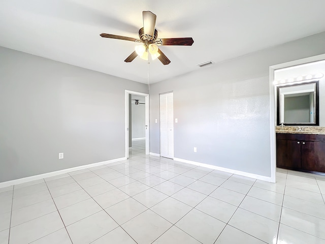 tiled spare room with ceiling fan