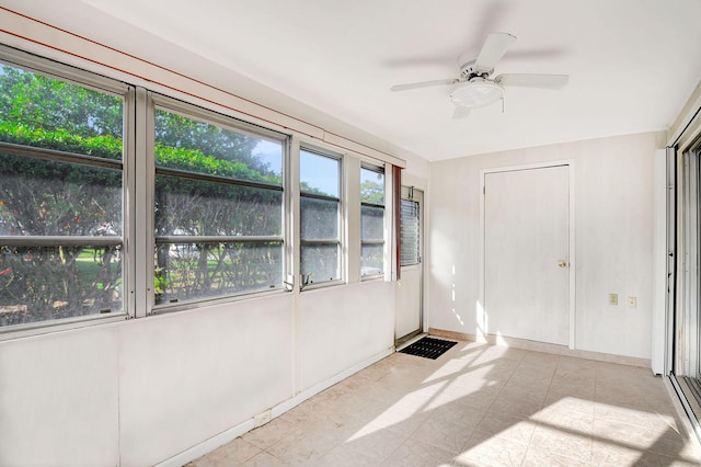 unfurnished sunroom with ceiling fan