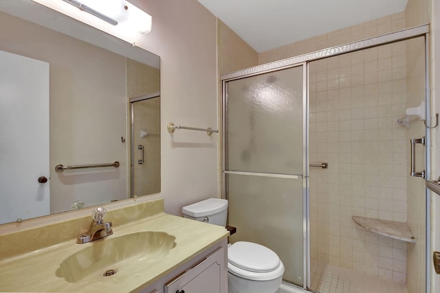 bathroom with vanity, a shower with shower door, and toilet