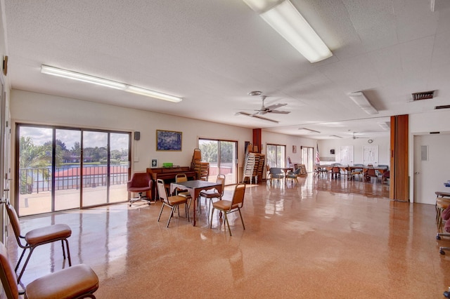 dining space with ceiling fan and a textured ceiling