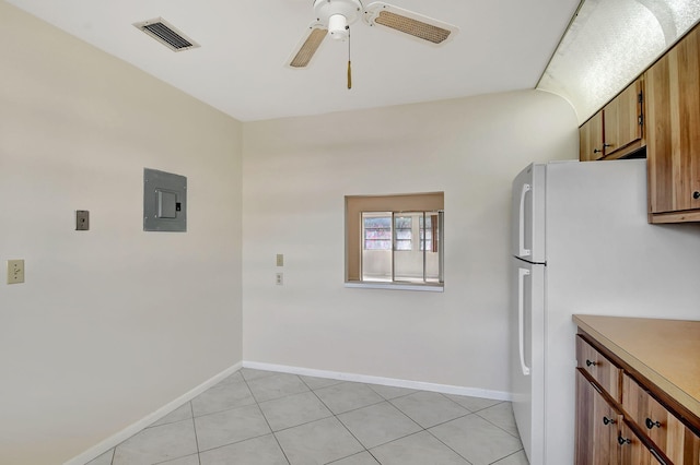 kitchen featuring white refrigerator, ceiling fan, electric panel, and light tile patterned floors