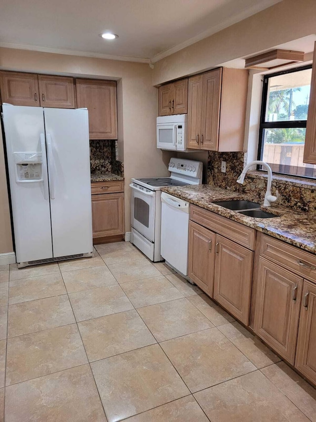 kitchen with backsplash, white appliances, sink, and dark stone counters