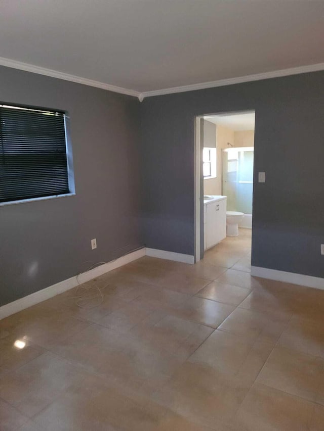 unfurnished room with light tile patterned floors and crown molding