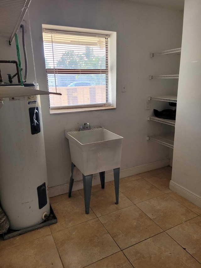 interior space with light tile patterned floors and electric water heater