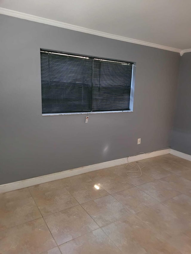 tiled spare room with crown molding