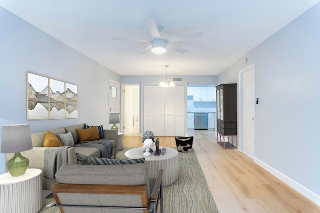 living room with light hardwood / wood-style flooring and ceiling fan with notable chandelier