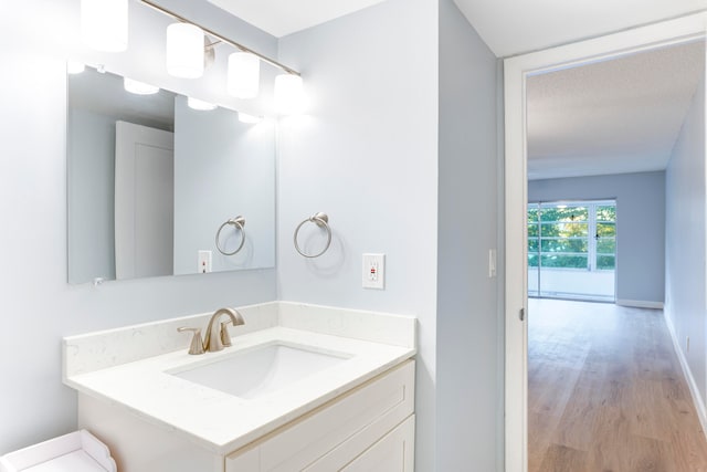 bathroom with hardwood / wood-style flooring, vanity, and a textured ceiling