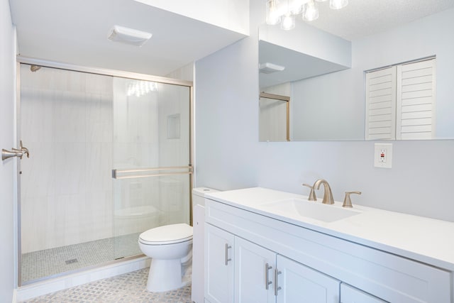 bathroom with vanity, tile patterned floors, toilet, a textured ceiling, and a shower with shower door