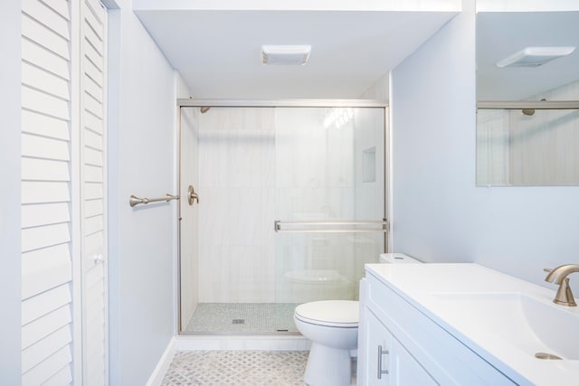 bathroom with tile patterned floors, vanity, toilet, and a shower with door