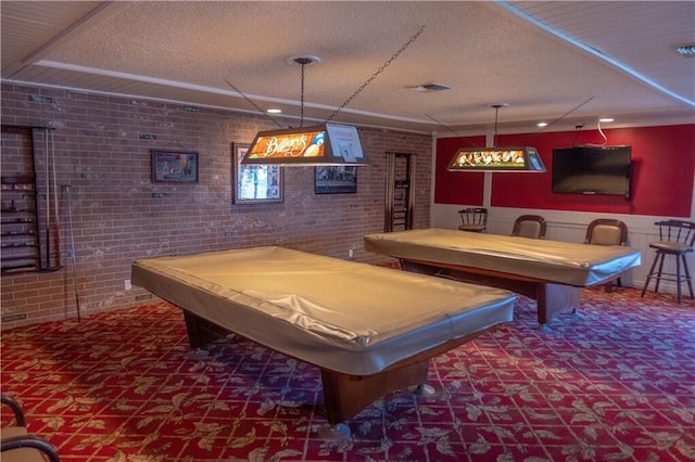 game room featuring brick wall, a textured ceiling, and pool table