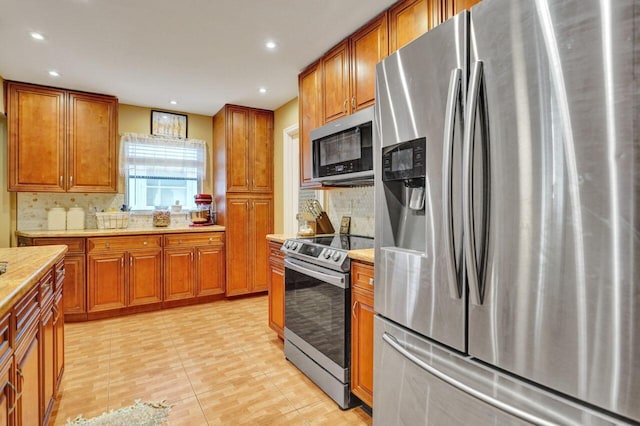 kitchen featuring appliances with stainless steel finishes, recessed lighting, brown cabinets, and decorative backsplash