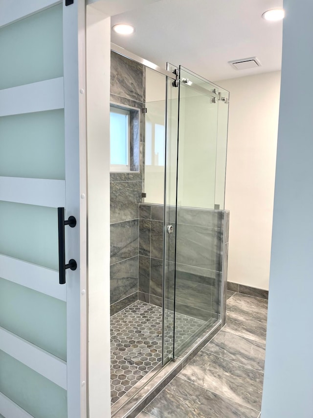 bathroom featuring wood-type flooring and an enclosed shower