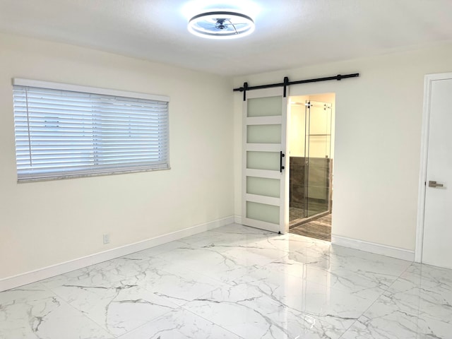 unfurnished bedroom with a barn door and a closet