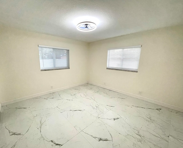 unfurnished room with a textured ceiling