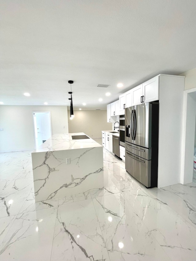 kitchen with white cabinetry, sink, stainless steel appliances, light stone counters, and pendant lighting