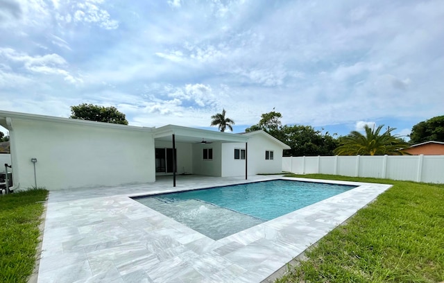 view of pool with ceiling fan, a yard, and a patio